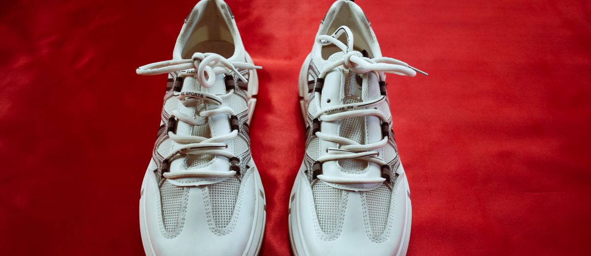 Paire de baskets blanches tendance sur fond rouge