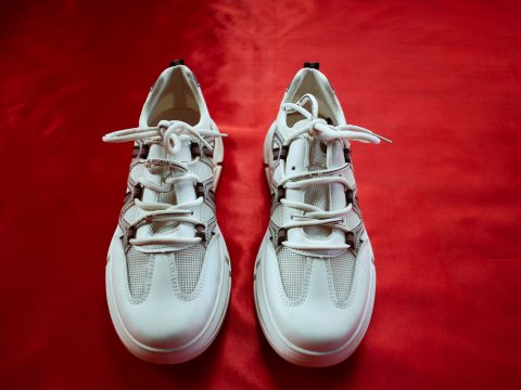 Paire de baskets blanches tendance sur fond rouge