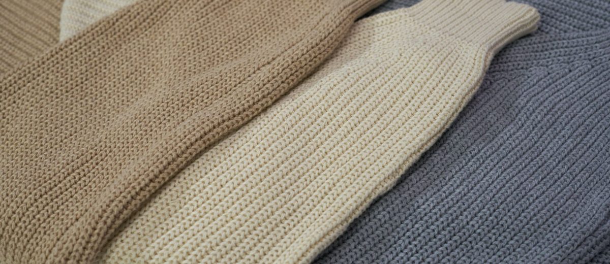 Pulls en laine beige et gris posés à plat, capsule pour s'habiller par 5 degrés