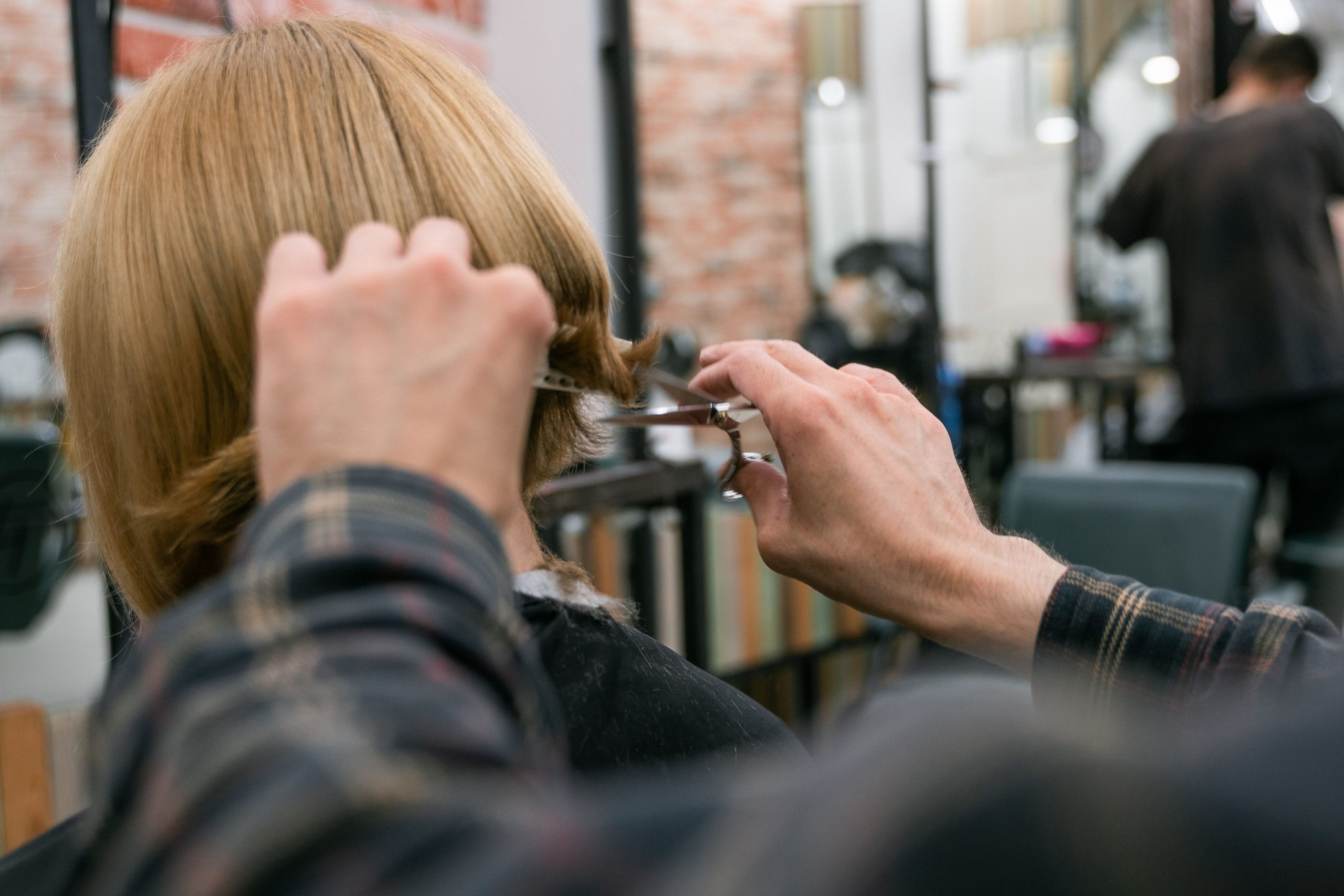 Coiffeur en train de couper une frange