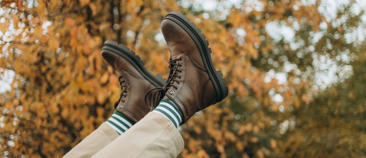 Paire de bottes marron confortables posées dans les feuilles d'automne