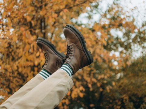 Paire de bottes marron confortables posées dans les feuilles d'automne